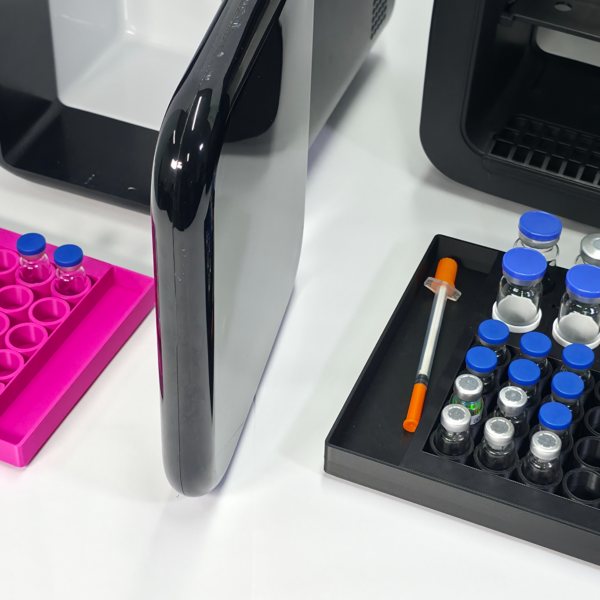 Laboratory vials in black and pink trays.